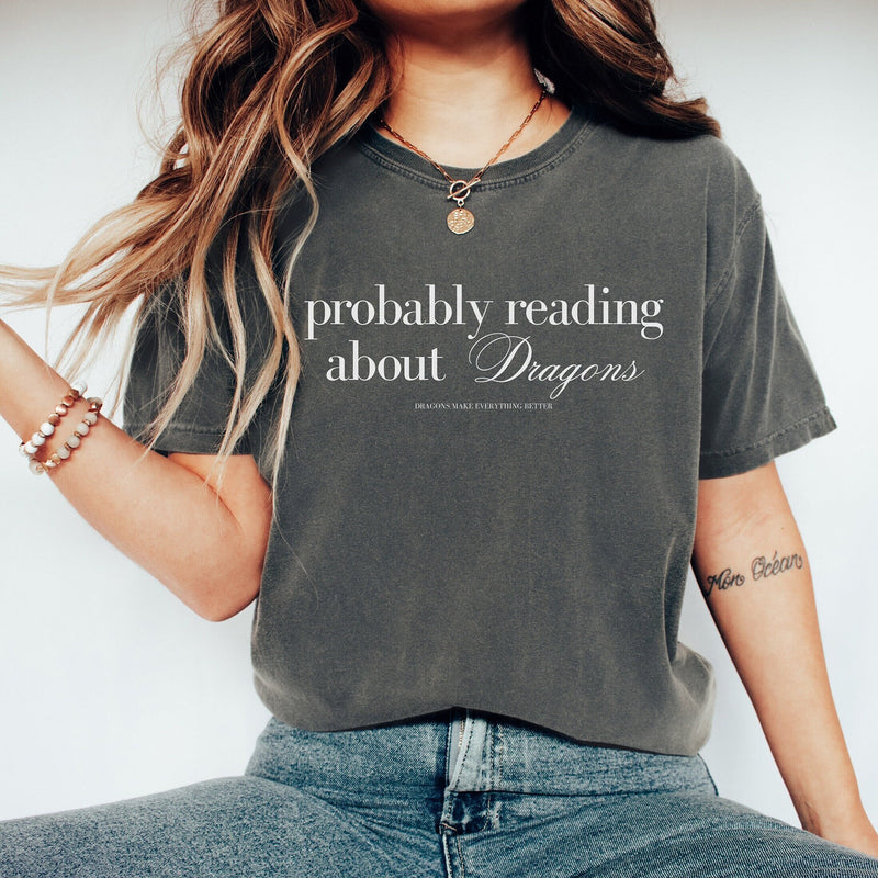 Show off your love for all things dragon-related with our "Probably Reading About Dragons" Shirt. Perfect for fantasy enthusiasts, this shirt combines comfort with a touch of whimsy, making it a must-have for your wardrobe.